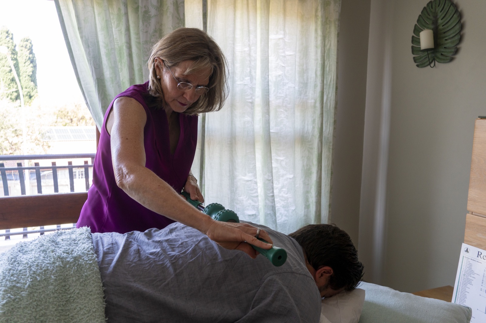 Renita using a deep magnetic massage roller during an in-person session