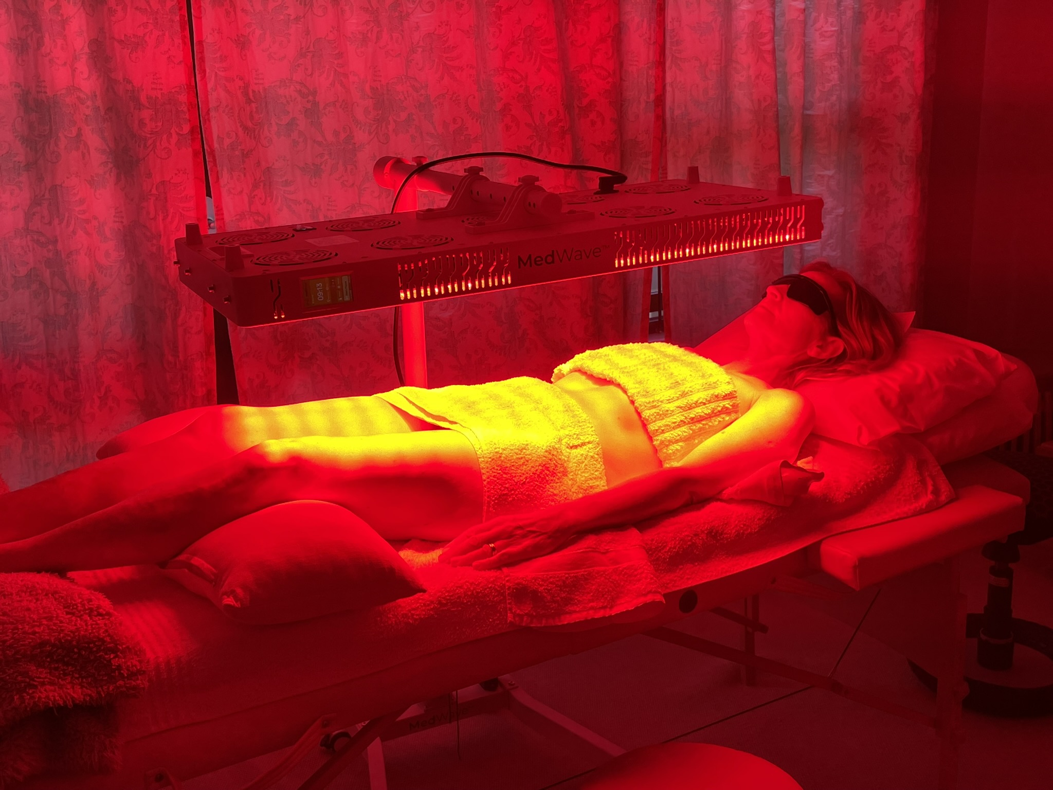 A client receiving full-body photobiomodulation beneath a MedWave light panel